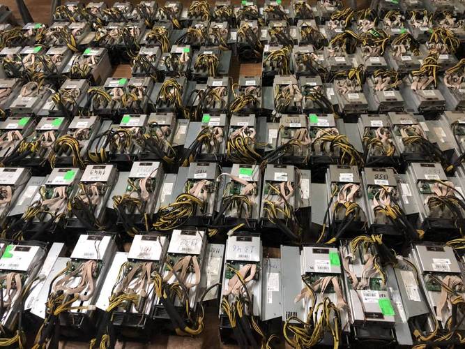 A cryptocurrency miner inspecting their ASIC